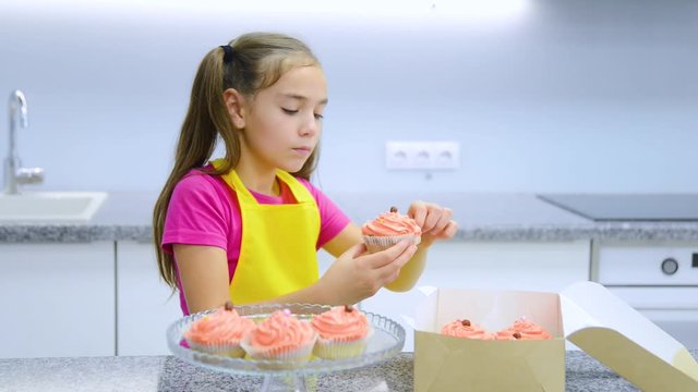 Smiling girl takes out the capcake from the gift box