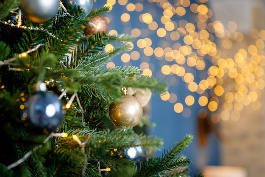 Modern design Christmas tree decorated with balls and garlands - navy blue, brown, beige. Winter holidays composition.