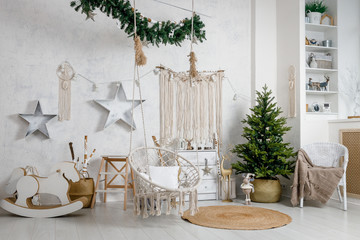 Modern interior design room with Christmas and New Year decorations, toys, gifts, fir tree, hanging swing. Winter holidays composition.