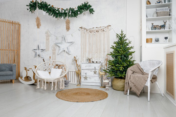Modern interior design room with Christmas and New Year decorations, toys, gifts, fir tree, hanging swing. Winter holidays composition.