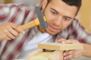 carpenter using hammer on wood