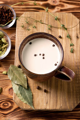  Masala tea with cinnamon, cloves, bay Indian tea with spices. Masala tea. National cuisine, cardamom, thyme, black pepper on a wooden table. Indian food. National cuisine. Breakfast