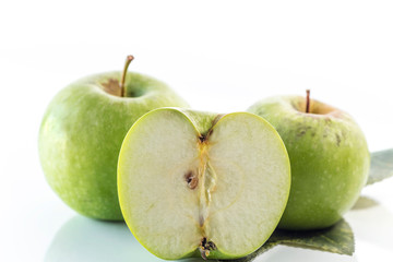 Two and a half organic green apples isolated on white background, close up