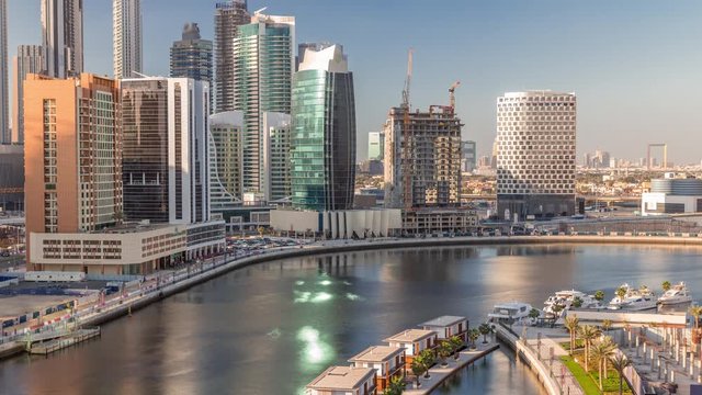 Modern skyscrapers near canal aerial timelapse with blue sky and water in canal in Business Bay district, Dubai, United Arab Emirates