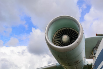 Aircraft jet turbine against a blue sky with clouds. Travel and business trips by plane.