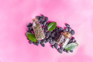 Flat lay composition with spa stones, green leaves and cosmetics, top view copy space