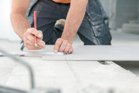  Fliesenleger bei der Arbeit , handwerker schneidet fliesen mit schneidetisch werkzeug