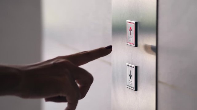 Female Hand Pushing Elevator Button in Office Center or Hotel. Young Woman Pressing Lift Button Up. 4K Slowmotion.