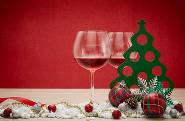 Red wine glasses and christmas balls on snow