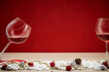 Red wine glasses and christmas balls on snow