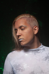 shaved young blond caucasian man on dark studio background