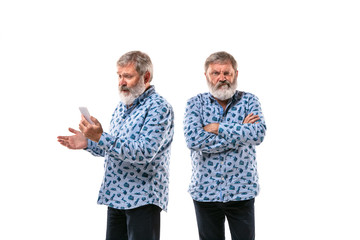 Senior man arguing with himself on white studio background. Concept of human emotions, expression, mental issues, internal conflict, split personality. Half-length portrait. Negative space. Angry.