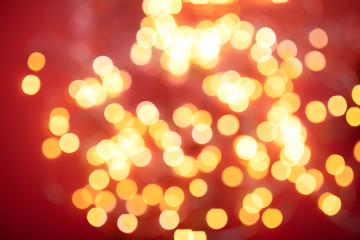 Golden round bokeh on red Christmas background.