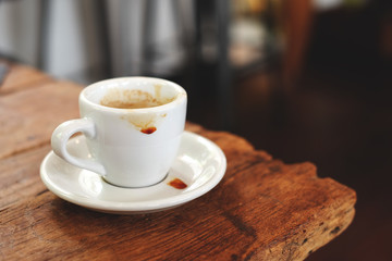 A cup of empty espresso coffee on the old wooden table in the morning.