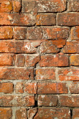 Texture of an old damaged brick wall with a big crack in it as a background