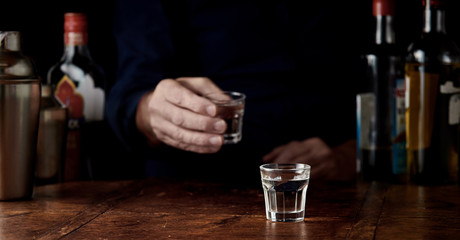 Bartender serving shots of vodka at a bar counter