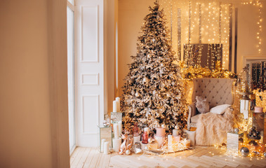 classical interior of a white room with a decorated fireplace, luxury Christmas tree, garlands, candles, lanterns, gifts. day golden pastel colors. new year