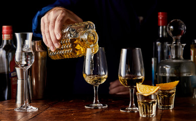 Barman serving alcoholic drinks from a decanter