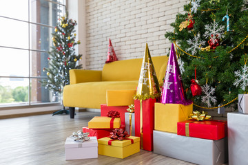 Christmas decoration with tree gift boxes hat by the Sofa in living room by the window, Christmas and happy new year concept.