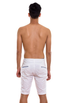 Studio shot of back view of young Persian man standing shirtless