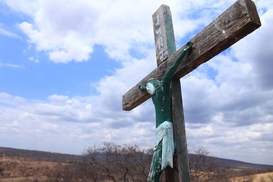 A green image of Jesus Christ nailed on a wooden cross at the top of a sacred hill in a black community in the interior of Brazil at the state of Piauí, drought and poor region