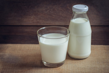 Obraz na płótnie Canvas Milk glass and bottle of milk on wooden table