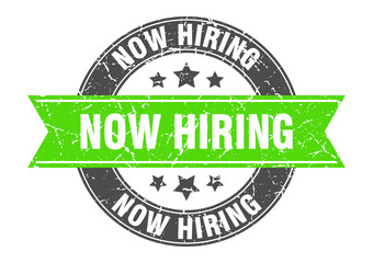 Obraz premium now hiring round stamp with green ribbon. now hiring