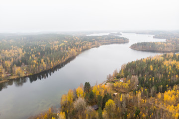 Naklejka na ściany i meble Aerial view of lake and colorful forests on a autumn day in Finland. Drone photography