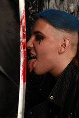 blue hair fashion guy with bloody sword on dark background