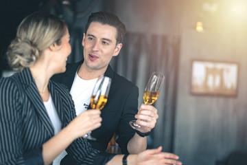 Man flirting on a woman while holding a glass of champagne at the bar.