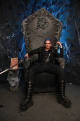 Fototapeta na wymiar blue hair fashion guy with bloody sword on dark background