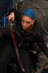 blue hair fashion guy with bloody sword on dark background