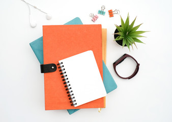 Top view black to school and education concept on white table desk with blank notepad and stack of book , green plant and supplies, Flat lay with copy space, work space