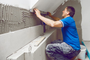 Tiler installing large format tile on wall. home indoors renovation