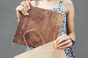 Girl takes out a wooden book from a craft package. Reading concept. Vintage tone.
