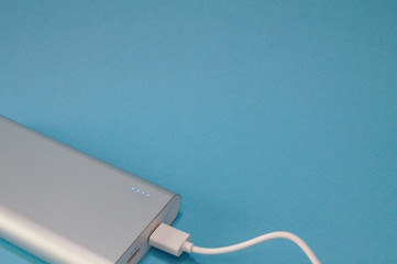 Obraz premium Isolated silver powerbank on a blue background