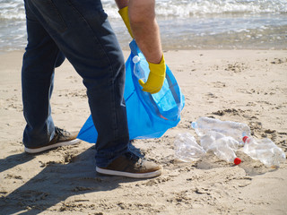 Man picking up a plastic bottle, save the environment, collecting trash
