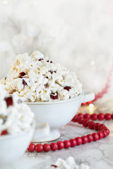 Homemade popcorn and dried cranberry snack covered in white chocolate ready for the holidays. Selective focus with blurred foreground and background.