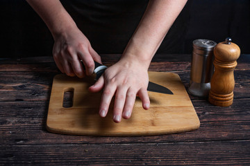 Chef at work. Cook's hands are tearing a knife over garlic. Preparing the ingredients for the future dish.