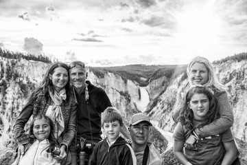 Two family with children enjoying the visit to a National Park. Amazing view of tourists and landscape with waterfalls on background
