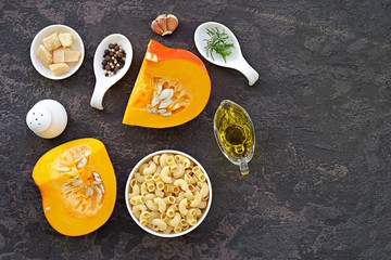 Ingredients for cooking pasta with pumpkin and parmesan: dry pasta, pumpkin, rosemary, parmesan, salt, pepper, olive oil. Italian food. Thanksgiving Day. Top view.