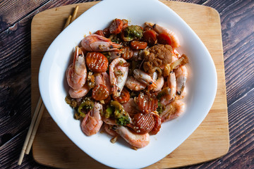 Cooked tasty dish fried shrimp with vegetables in sweet and sour sauce.