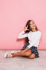 Girl child posing isolated over pink wall background - obrazy, fototapety, plakaty