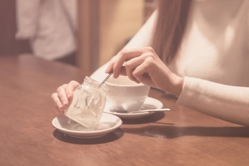 woman eats vanilla dessert sitting in a restaurant