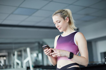 Frau benutzt ihre Fitness App auf dem Smartphone