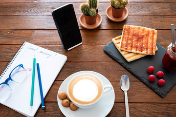 Good morning breakfast. Wooden rustic table with a homemade cappuccino and homemade marmelade....
