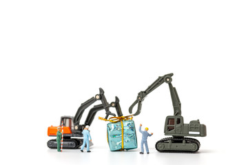 Miniature people working on a gift box