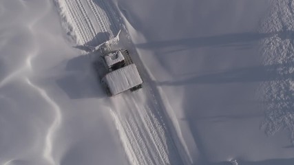 Aerial shot: View of mountain peaks covered in deep snow, while ascending with a snow cat during a day of cat skiing. Epic snowy mountains with Snow groomer. transfer by snowcat freeride - Powered by Adobe
