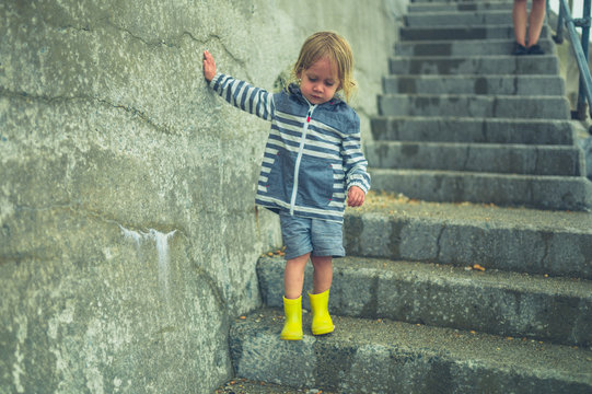 Little toddler walking down some steps outdoors