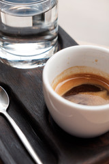 black coffee in a cup and a glass with water